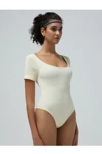 Close-up of cream ribbed texture on a seamless short sleeve bodysuit with a round neck