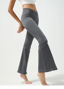 Detail of cross V-waistband design on high waisted flared ribbed yoga pants in dark grey
