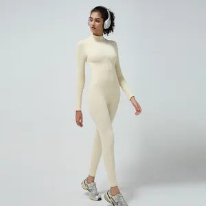 Close-up of beige ribbed knit yoga bodysuit featuring high-neck half-zipper detail