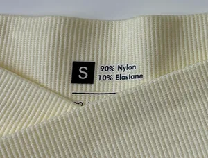 Detailed macro view of the seamless waistband with 90% nylon and 10% elastane fabric labels