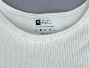 Vista macro del reggiseno sportivo a coste bianco con etichetta materiale e trama del tessuto