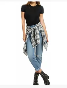 Detail einer zerrissenen blauen Jeans kombiniert mit schwarzem T-Shirt und Karohemd