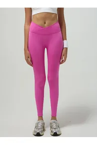 Dettaglio dei leggings yoga rosa acceso con vita a incrocio e tessuto a coste