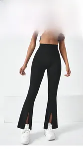 Détail de la fente frontale sur le bas du legging de yoga noir évasé à taille haute