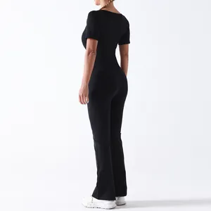 Combinaison de yoga noire ajustée à manches courtes et pantalon large évasé