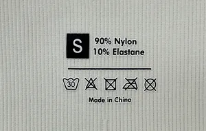 Détail de l'étiquette en tissu indiquant la taille S et 90% Nylon 10% Élasthanne