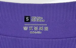 Detail of purple ribbed yoga pants label showing 90% Nylon and 10% Elastane fabric