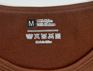 Detail of round neckline with size M label and 90% nylon fabric texture on brown jumpsuit