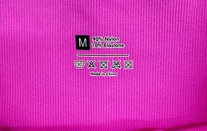 Detail of high-stretch seamless rib-knit fabric with M size label and care instructions