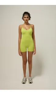 Detail of neon green one-piece yoga bodysuit with cross straps and built-in chest pads