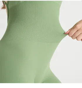 Detailed view of high-elasticity ribbed fabric on a green yoga bodysuit for tummy control