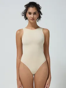 Dettaglio del body beige a costine senza cuciture con scollo rotondo e taglio senza maniche