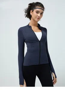 Close-up view of navy blue seamless yoga jacket featuring full zipper and thumb holes
