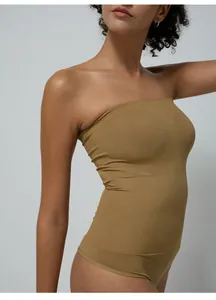 Detail of seamless tan shaping bodysuit showing high-elasticity fabric and smooth texture