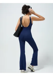 Detail of navy blue backless yoga jumpsuit showing seamless fabric and flare leg design
