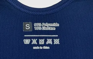 Detailed view of dark blue yoga jumpsuit care label with size S and material composition