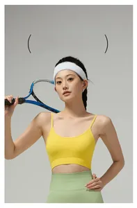 Detail of yellow sports bra with thin straps and ribbed band in a tennis court setting