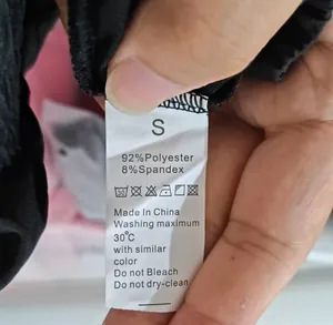 Detalle de la etiqueta de cuidado en pantalones de yoga con talla S y composición textil