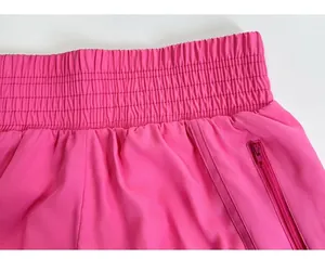 Detalle de pantalones cortos de yoga rosa con cintura elástica y bolsillo lateral con cremallera