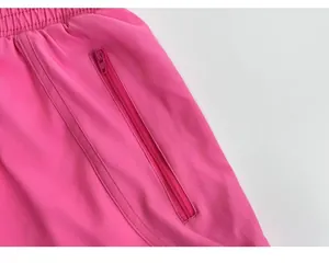 Detalle de los pantalones cortos deportivos rosas con bolsillo de cremallera y cintura elástica
