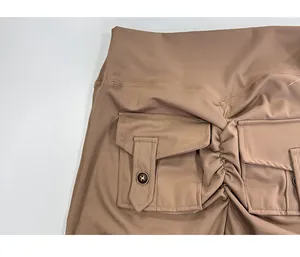 Macro view of brown cargo yoga pants featuring ruched butt lift and buttoned pockets