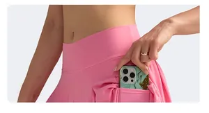 Detail of high-waisted pink sports skirt showing the functional side pocket for a phone