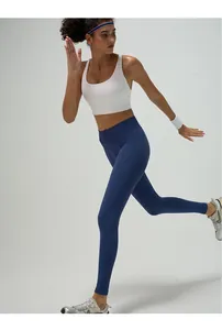 Detail of high-waisted navy yoga leggings and white sports bra on running model