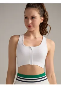 Dettaglio della cerniera frontale su un reggiseno sportivo bianco ad alto impatto fitness