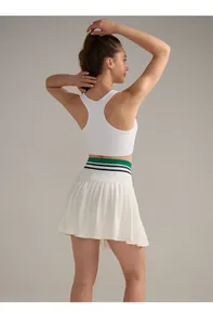 Vista posteriore completo da tennis bianco con top racerback e gonna a pieghe a righe