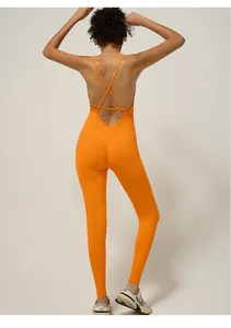 Macro shot of seamless bright orange yoga jumpsuit featuring criss-cross back straps