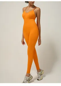 Side view of seamless ribbed yoga jumpsuit with open back and orange crossover straps