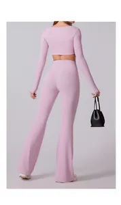 Rückansicht der rosa Yoga-Set mit Schlaghose und bauchfreiem Langarm-Oberteil