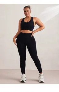Detail of high waist seamless yoga leggings and front zipper sports bra set in black