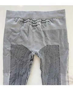 Dettaglio dei leggings compressivi grigi senza cuciture con vita alta e motivi in maglia