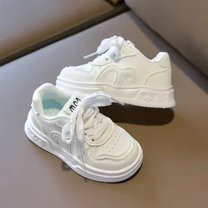 Detail of white kids sneakers featuring poker pattern embossed soles and leather texture