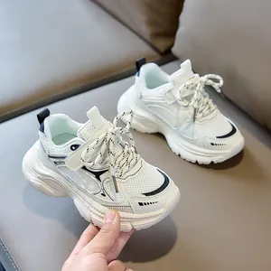 Detail of white kids chunky sneakers showing breathable mesh and fashion lettering
