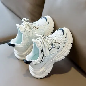 Detail of white mesh kids sneakers with fashion logo and velcro closure on dark background