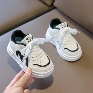 Detailed close-up of white and black kids sneakers with soft sole and velcro closure