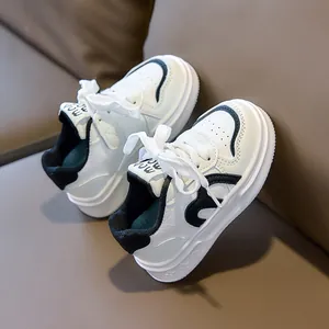 Close-up of children white sneakers featuring black wave accents and heart pattern soles