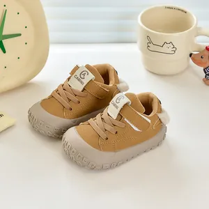 Détail de chaussures bébé montrant l'embout en caoutchouc et la bande velcro