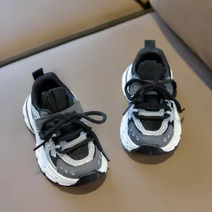 Detail view of breathable mesh and layered faux leather stitching on kids sports shoes