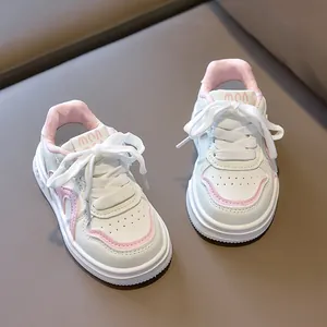 Detail of white and pink kids sneakers with synthetic leather upper and velcro laces