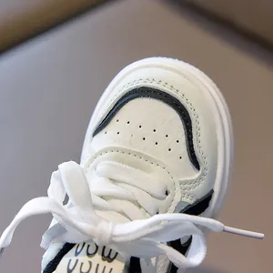 Detailed macro view of children's white sneakers showing leather texture and stitching