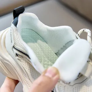 Detail view of breathable mesh lining and padded collar on white kids sports sneakers