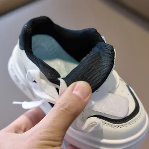 Detail of soft mesh lining and padded blue insole on white kids' athletic sneakers
