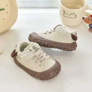 Détail de chaussures de marche pour bébé avec semelles souples et pompons au talon