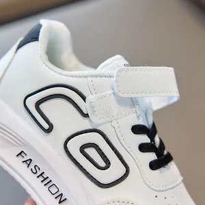 Λεπτομέρεια από λευκό δερμάτινο παιδικό sneaker με λογότυπο CD και μαλακή μύτη που αναπνέει