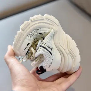 Close-up of flexible white kids sneakers showing the soft and bendable anti-slip sole