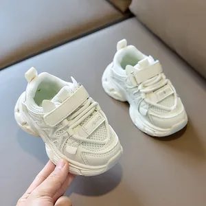 Detail of white kids athletic sneaker showing breathable mesh and velcro strap closure
