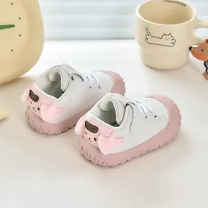 Détail de chaussures de marche bébé avec oreilles roses et bout protecteur robuste